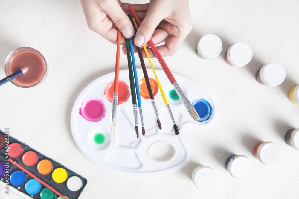 Girl painter holding lots of brushes. Girl painter holding lots of brushes.