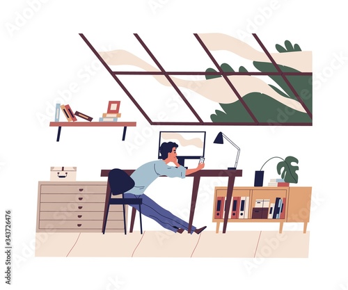 Smiling young man has a work break. Freelancer sitting at desk with smartphon...