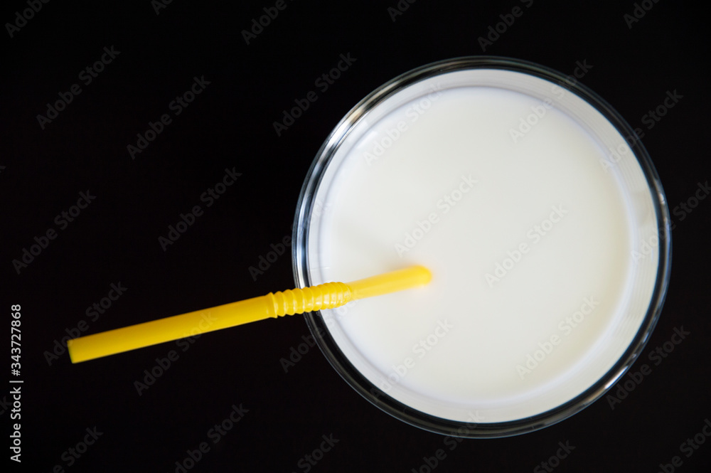 milk with a straw in a glass on a black table milk with a straw in a glass on a black table