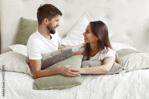 Cute couple in a bedroom. Lady in a white t-shirt. Pair at home