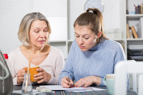 Woman with  daughter filling documents