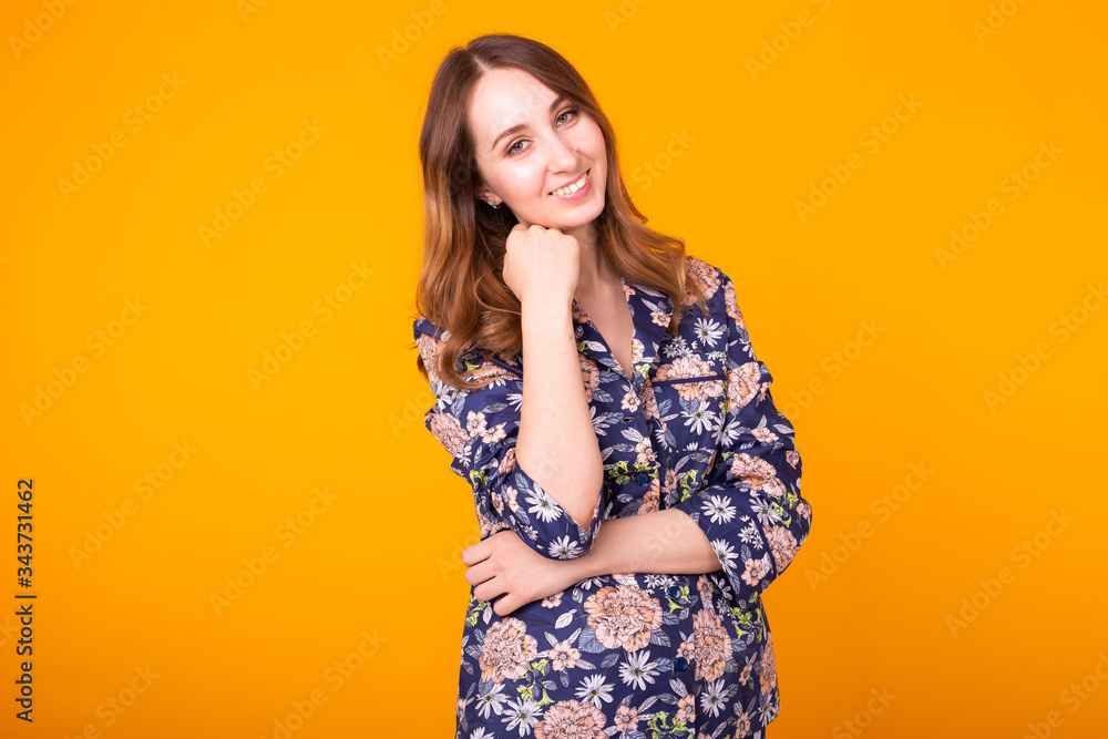 Cute and cheerful woman in home wear pajama studio lifestyle yellow background emotions. Cute and cheerful woman in home wear pajama studio lifestyle yellow background emotions.