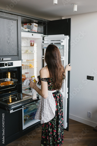 Beautiful young woman preparing dinner in the kitchen. The concept of a healthy diet and lifestyle.