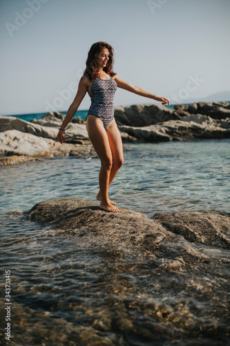 Young woman in bikini walki...