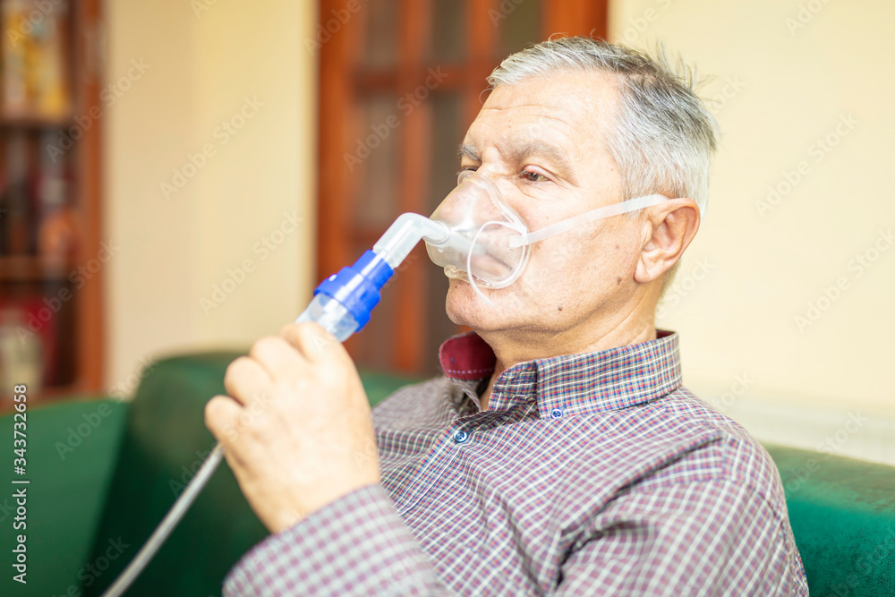 Senior man using medical equipment for inhalation with respiratory mask, nebulizer Senior man using medical equipment for inhalation with respiratory mask, nebulizer