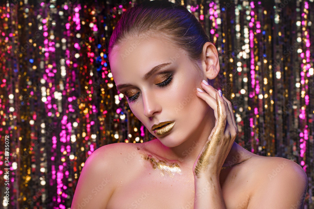 Beauty portrait of a High Fashion model woman in colorful bright neon lights posing in studio, night club On colourful vivid sequin background.