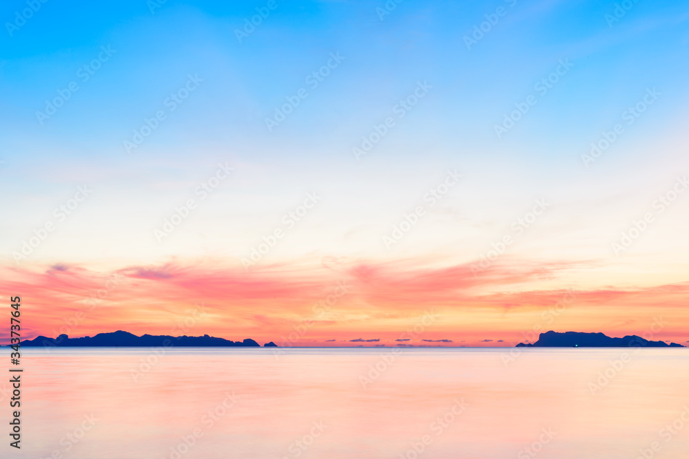Beautiful beach sunset with blue sea and golden light sky  cloud background,long exposure technique