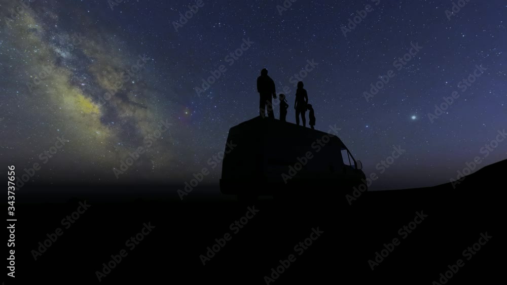 Silhouettes of people stand on the roof of the car and look at the stars. Family mother daughter son father. Happy family. 4k Silhouettes of people stand on the roof of the car and look at the stars. Family mother daughter son father. Happy family. 4k