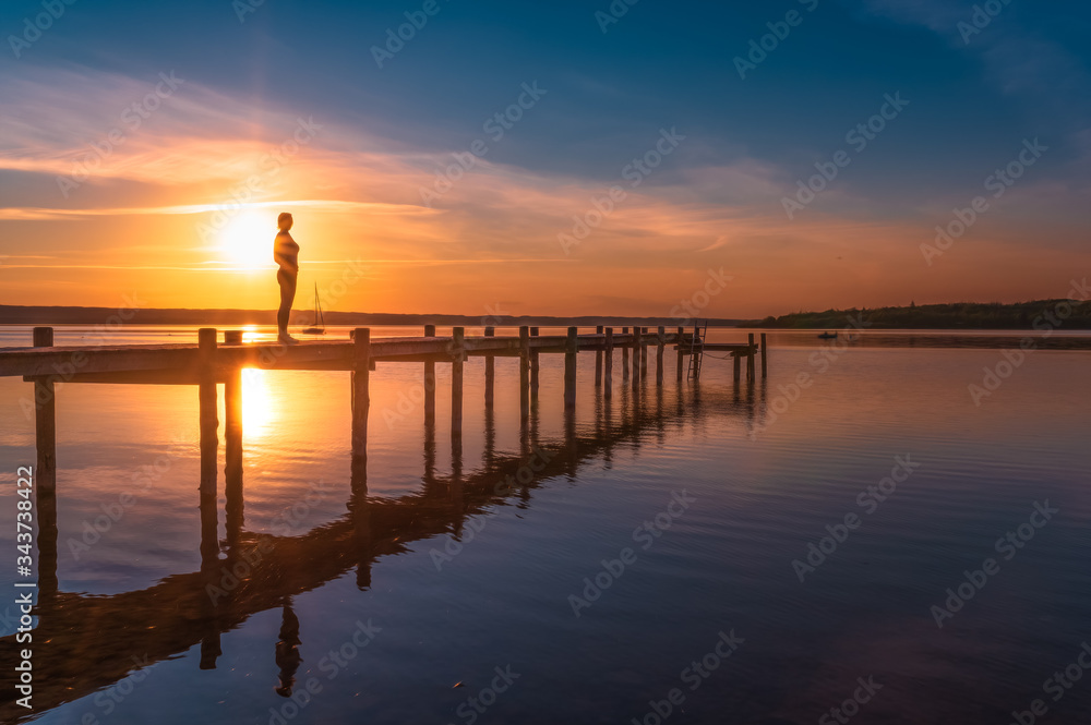 Frau genießt den Sonnenuntergang am Ammersee