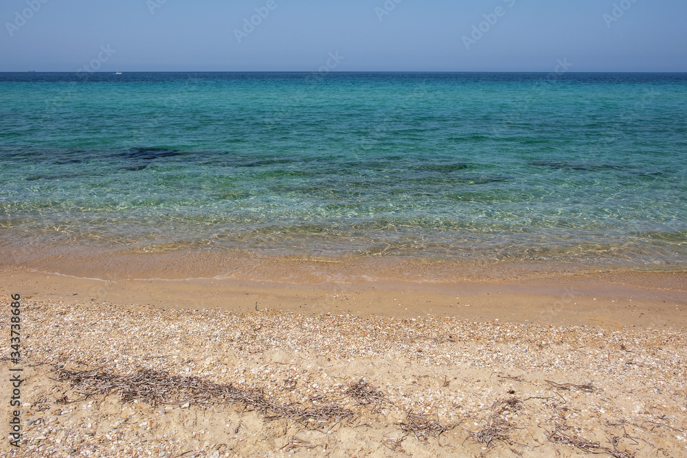 The endless expanse of the sea and sandy beach. Transparent waves, Halkidiki, Greece.