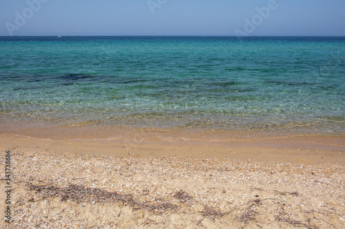The endless expanse of the sea and sandy beach. Transparent waves, Halkidiki, Greece.