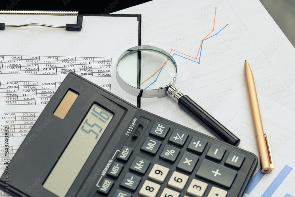 Business financial documents, office calculator and pen on the table. Numbers and graphs Business financial documents, office calculator and pen on the table. Numbers and graphs
