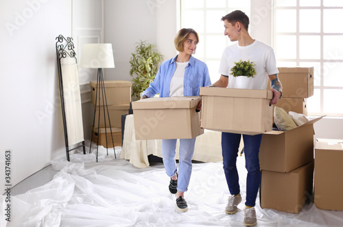 Couple holding boxes for moving the hands and looking inside box