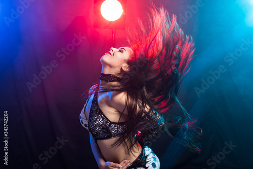 Belly dancer. Young attractive woman dancing tribal fusion on the stage. Oriental exotic dance.