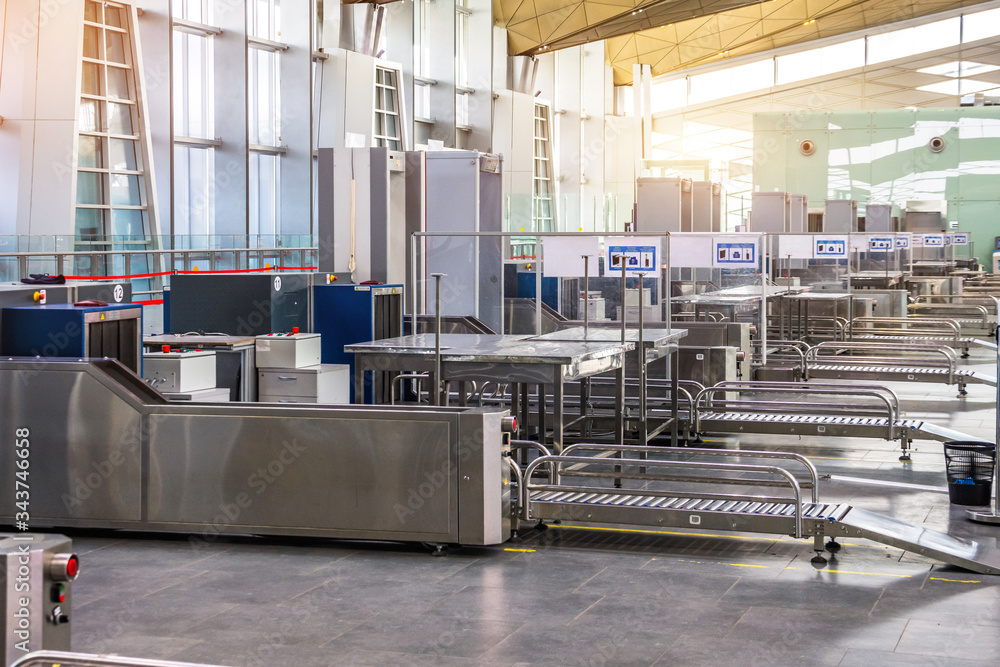 X-ray machine for screening passenger luggage with frame metal detector at the airport check-in counter. X-ray machine for screening passenger luggage with frame metal detector at the airport check-in counter.
