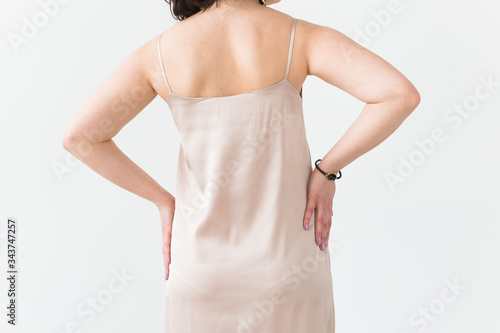 Fashion photo of young lady in elegant evening dress on white background, close-up back view.