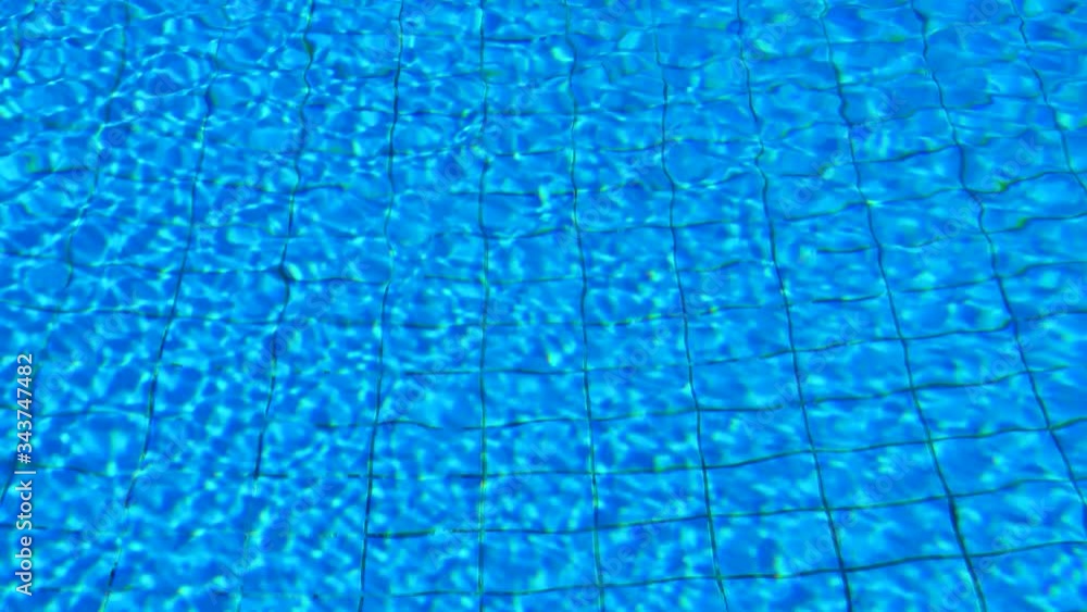 Pure Blue Water In The Swimming Pool. Ripple And Waves In Clear Turquoise Water, Soft Wind. Water Pool Aqua Surface Background. Relaxation At The Resort. Pure Blue Water In The Swimming Pool. Ripple And Waves In Clear Turquoise Water, Soft Wind. Water Pool Aqua Surface Background. Relaxation At The Resort.