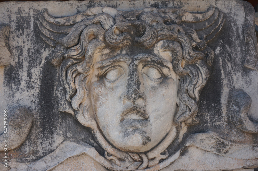 The face made of stone scares with its antiquity. Ruins of the temple of Apollo, the ancient Greek sanctuary of Didyma. Didim, Turkey. The face made of stone scares with its antiquity. Ruins of the temple of Apollo, the ancient Greek sanctuary of Didyma. Didim, Turkey.