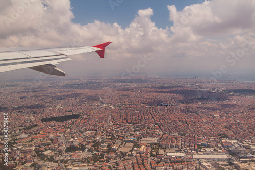 view of clouds and wing from the plane, view of the city from above. Concept of urban development, tourism and travel, passenger air transportation.