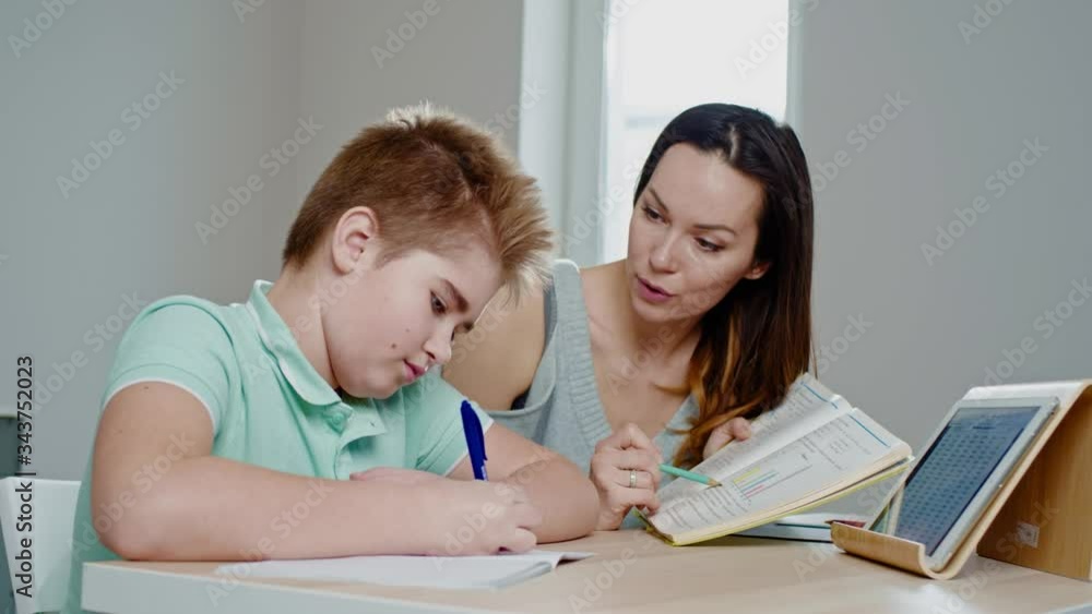 Mother with her son studying online at home Mother with her son studying online at home