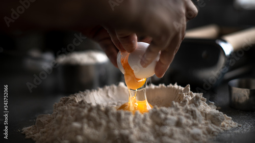 Process of making homemade wholewheat pasta in a kitchen with pasta sheet roller. Close up view. Dark photography