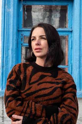 woman on the background of the window. brunette outside a residential building