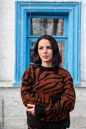 woman on the background of the window. brunette outside a residential building