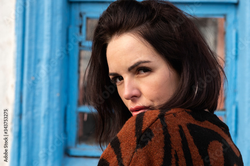 woman on the background of the window. brunette outside a residential building