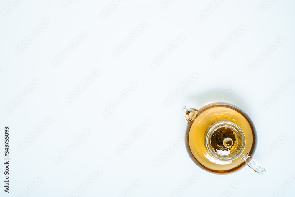 glass teapot and cups with hot tea on table, top view