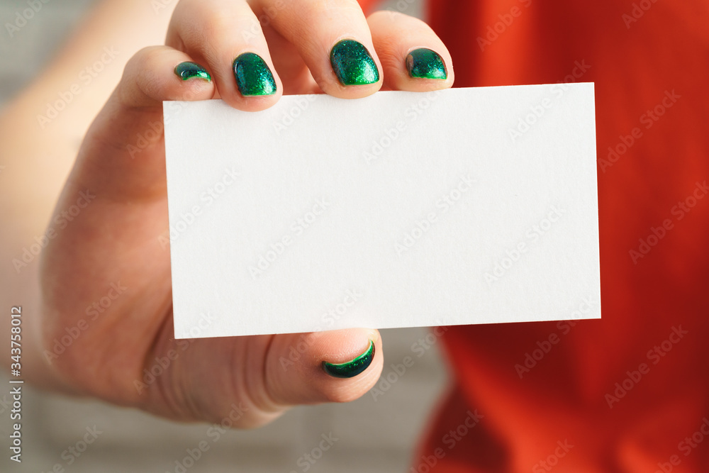 Obraz premium Girl's hand holding blank white business card close up