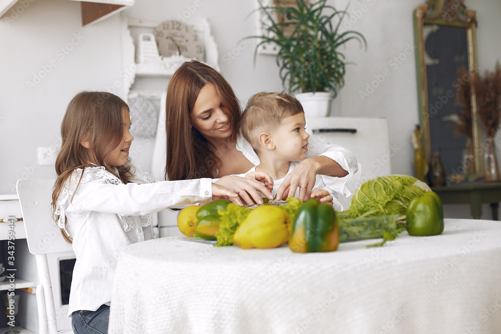 Fototapeta premium Family in a kitchen. Beautiful mother with children. Lady in white blouse.