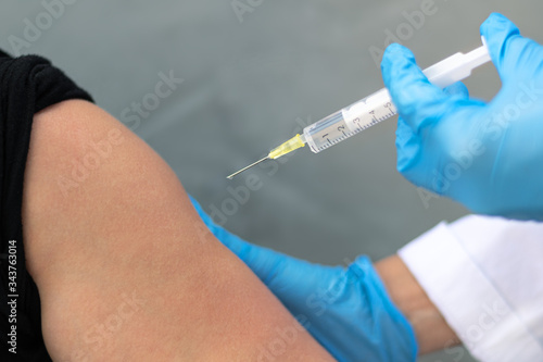 Biology and science. Doctor holding a syringe  giving vaccination. Global alert. Vaccination. Influenza. Covid-19. Coronavirus. Research.