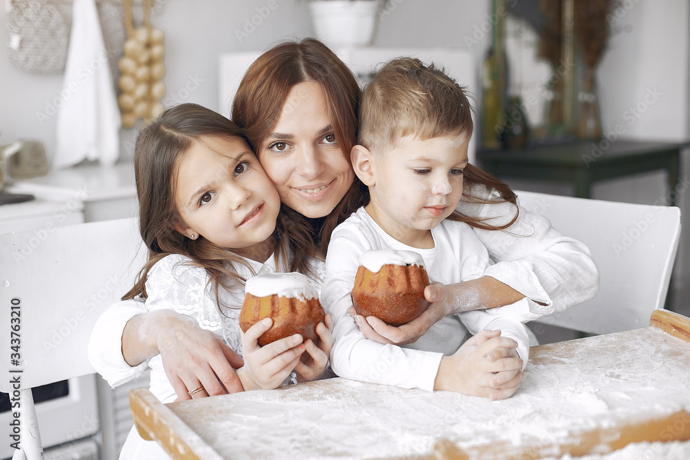 Family in a kitchen. Beautiful mother with children. Lady in white blouse. Family in a kitchen. Beautiful mother with children. Lady in white blouse.