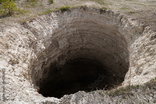 Fotografie, Obraz Round karst sinkhole, formed above abandoned limestone mine