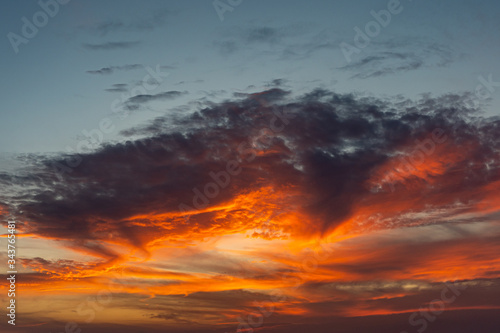 Dramatic sky with clouds and orange sunset at nightfall time © Quang
