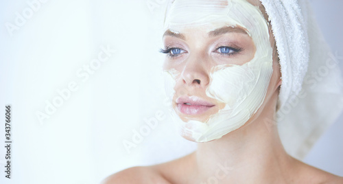 A picture of a young woman applying face powder in the bathroom