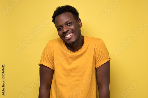 african american man in yellow clothes, smiling broadly