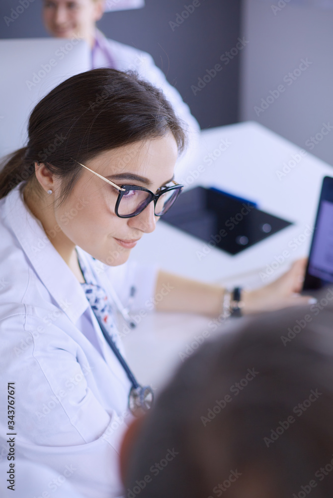 Serious medical team using a laptop in a bright office Serious medical team using a laptop in a bright office