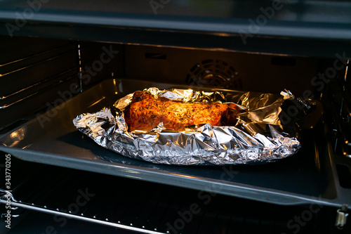 A large piece of baked meat. Chef preparing food. Grilled meat on the oven