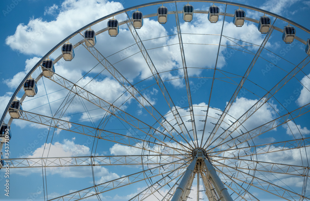 A modern white Ferris wheel against brilliant blue sky A modern white Ferris wheel against brilliant blue sky