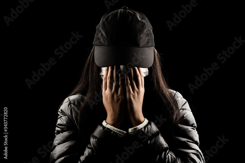 Female wear mask and hand covering face  sad crying on black background people worry unhappy protect virus carona covic 19 photo