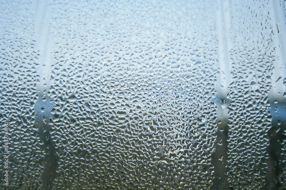 Closeup shot of a steamy window with water drops made in dull day..