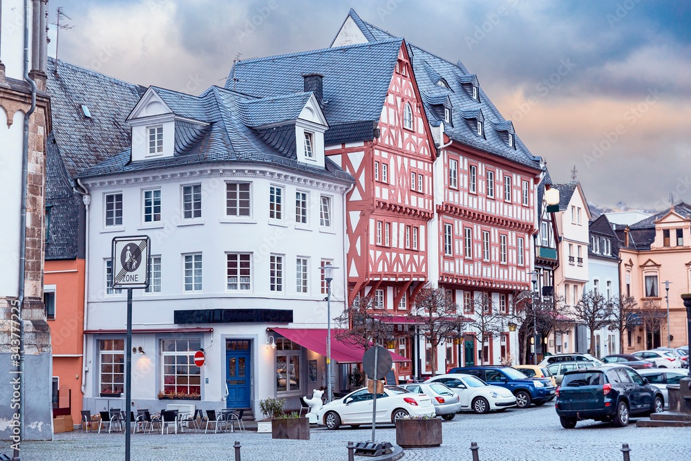 view of the town square with parked cars and a beautiful half-timbered house in the old German town of Mainz
