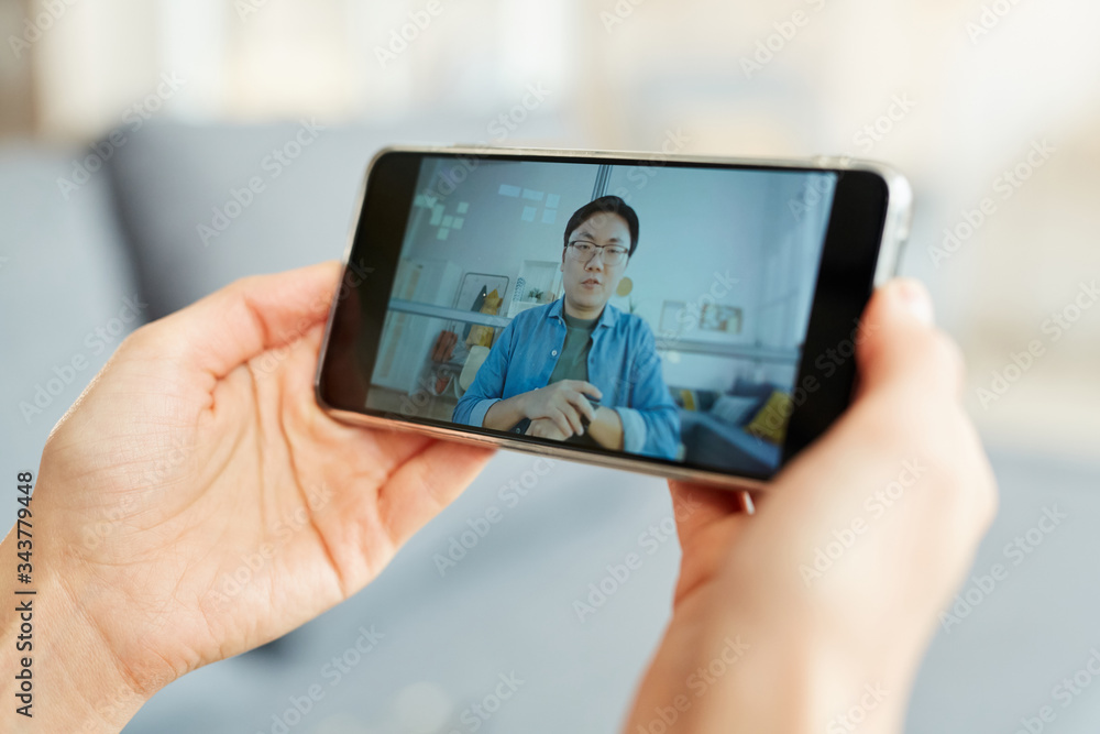 Unrecognizable person taking part in online video conference using smartphone, horizontal close-up shot