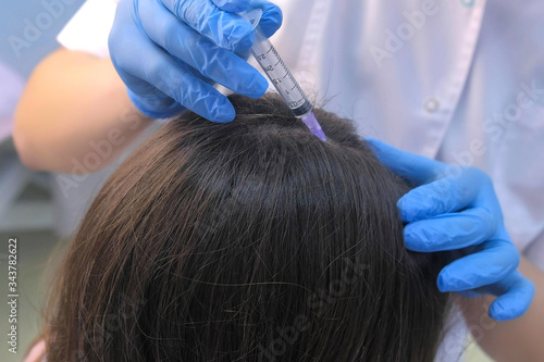 Doctor trichologist making multiple injections mesotherapy in woman skin head for hair growth in cosmetology clinic, closeup hands view. Making treatment procedure to patient for hair cure.