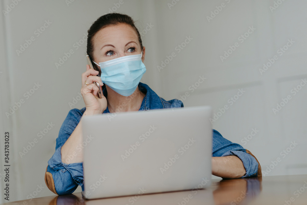 Frau beim Home-Office mit Mundschutzmaske Frau beim Home-Office mit Mundschutzmaske