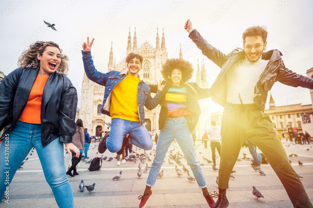 Obraz premium Group of for multiethnic people friends jumping in front of milan cathedral