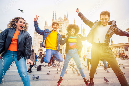 Group of for multiethnic people friends jumping in front of milan cathedral