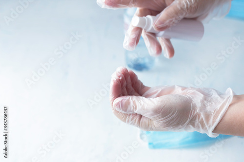 hand disinfection, a woman disinfects hands with rubber gloves with a sanitizer, coronavirus
