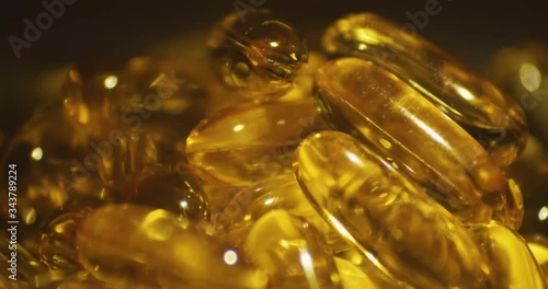 A close up macro shot of vitamin supplement containing cod liver oil reflecting light and liquid inside. photo